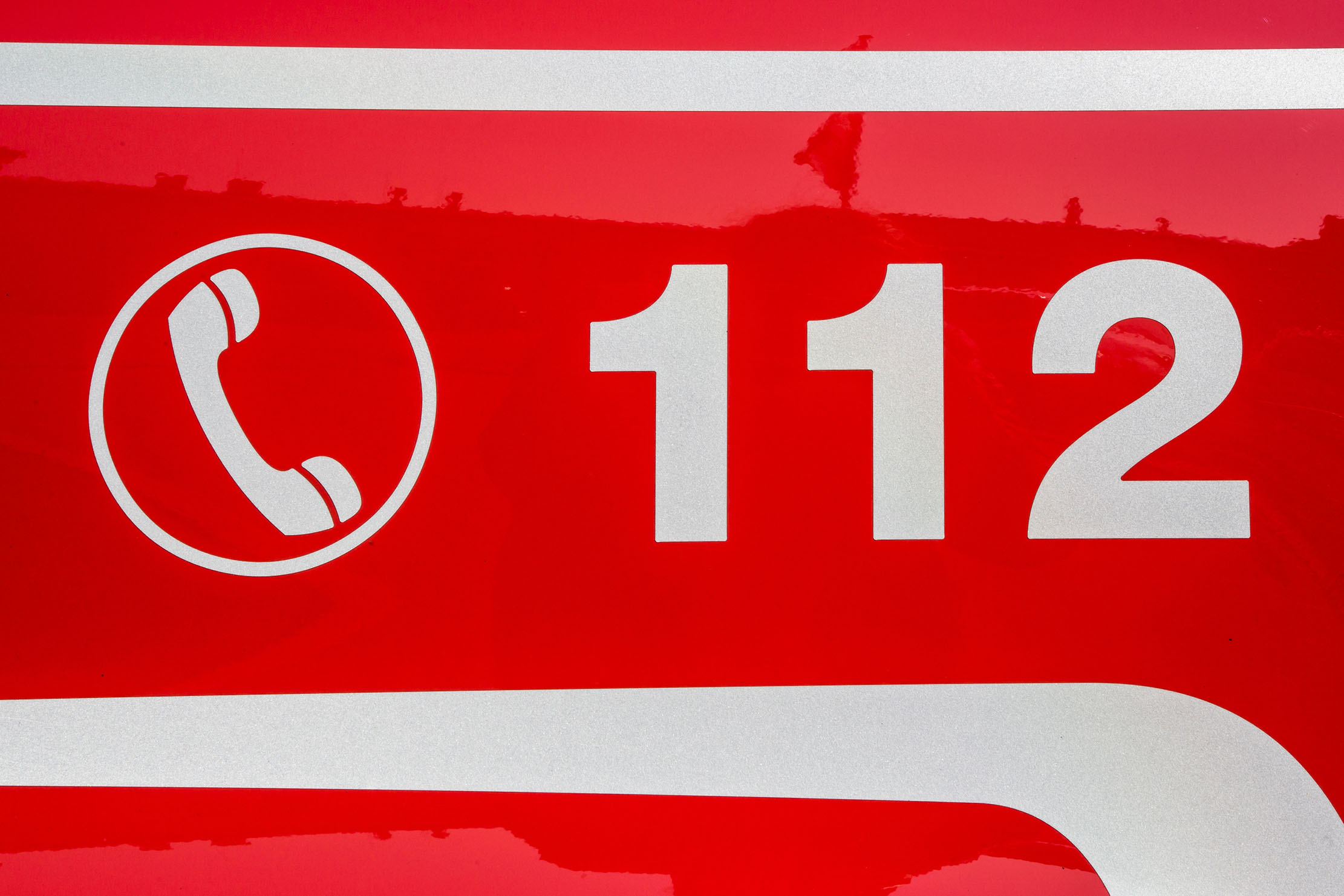Weißes Telefonsymbol und Notrufnummer 112 auf rotem Grund