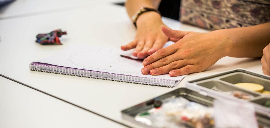 Hände bearbeiten ein formbares Material auf einer Tischplatte