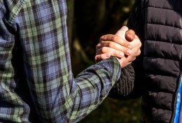 Zwei männliche Jugendliche begrüßen sich mit einem Faust-Handschlag