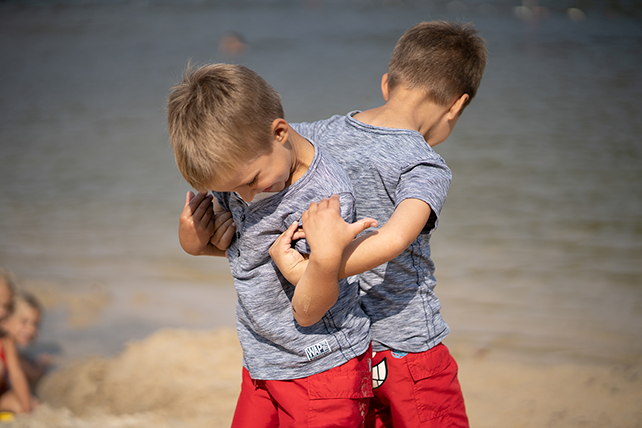 Jungen Zwei Jungen haben sich Rücken an Rücken eingehakt