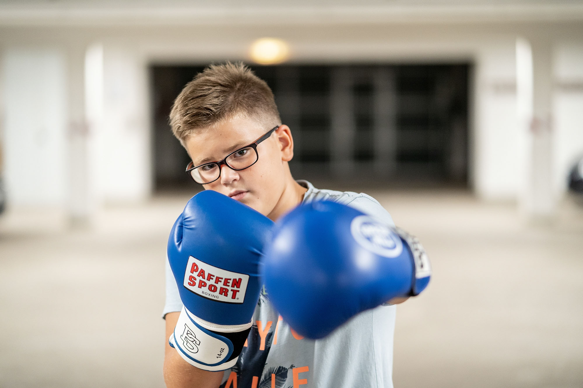 Boxen Junge mit blauen Boxhandschuhen