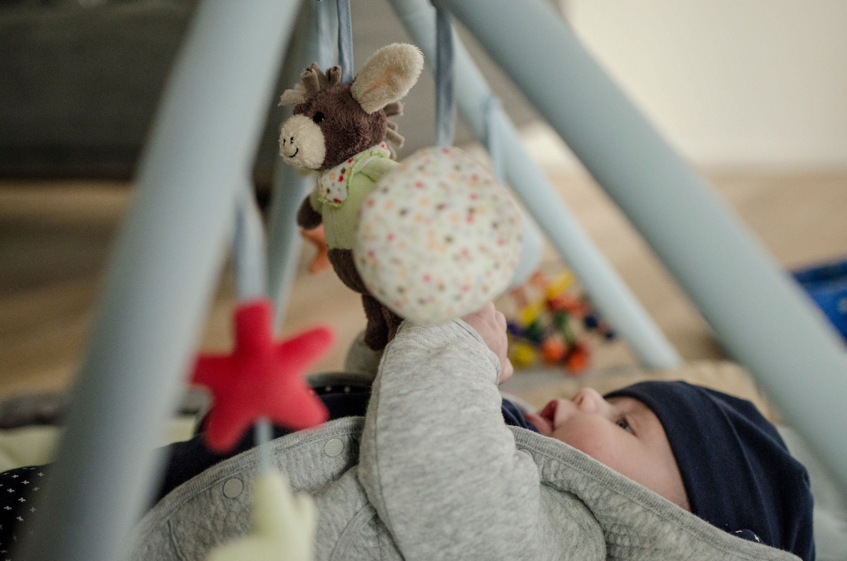 Babyspielzeug Ein Baby spielt mit einem Mobile