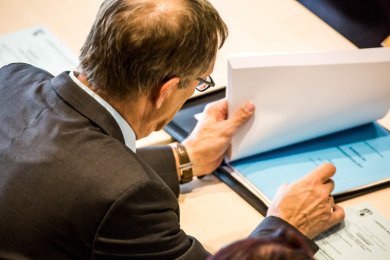 KT-Sitzung Mann liest in Sitzungsunterlagen
