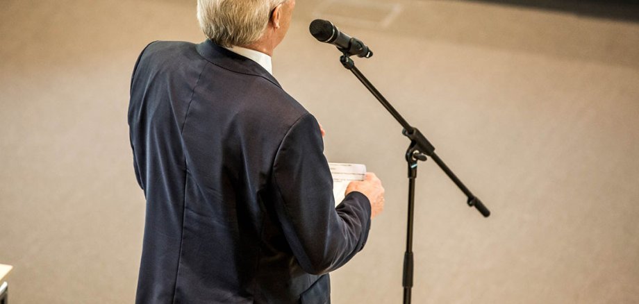 Rückenansicht eines Mannes am Mikrofon