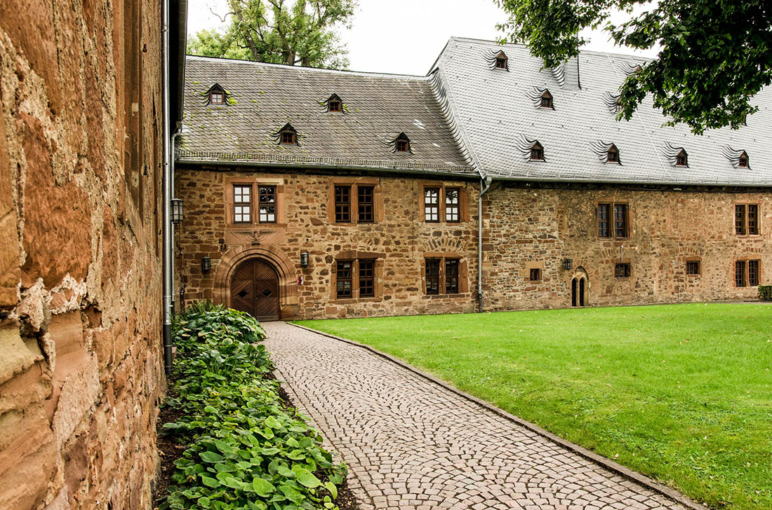 Weg und Wiese in einem Innenhof eines alten Klostergebäudes