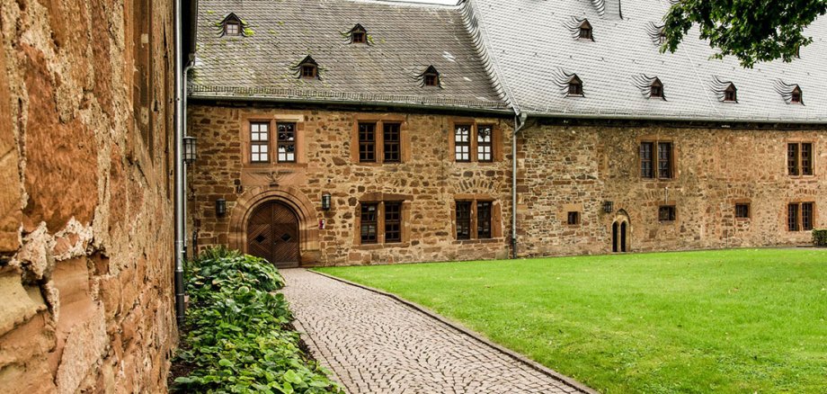 Weg und Wiese in einem Innenhof eines alten Klostergebäudes