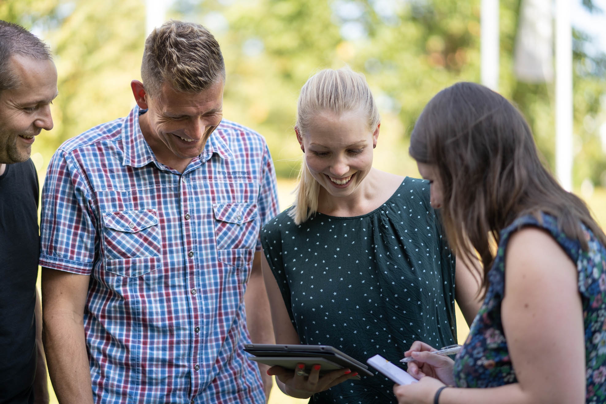 Vier Personen schauen auf ein iPad