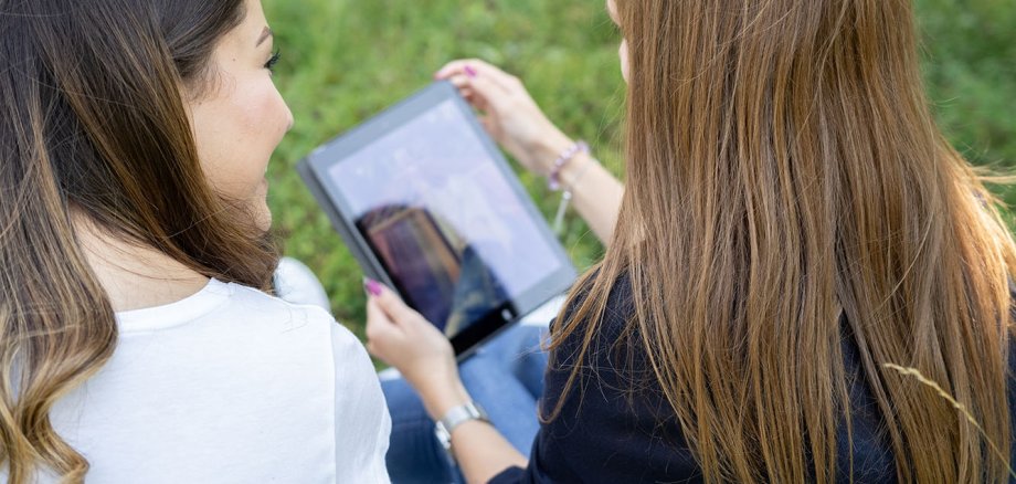 Zwei Mädchen schauen auf ein Tablet