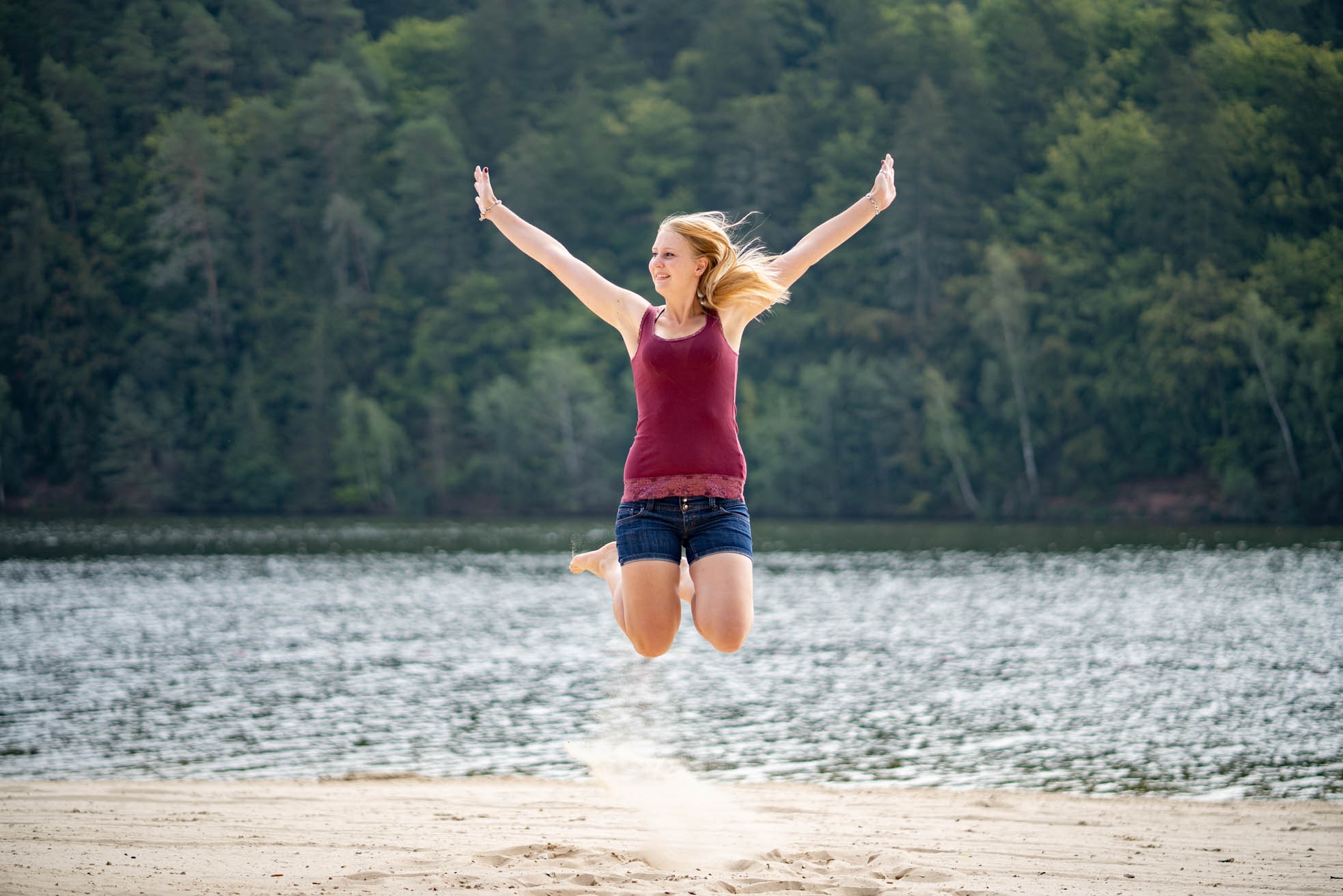 Strandbad Twistesee Junge Frau springt vor See in die Luft