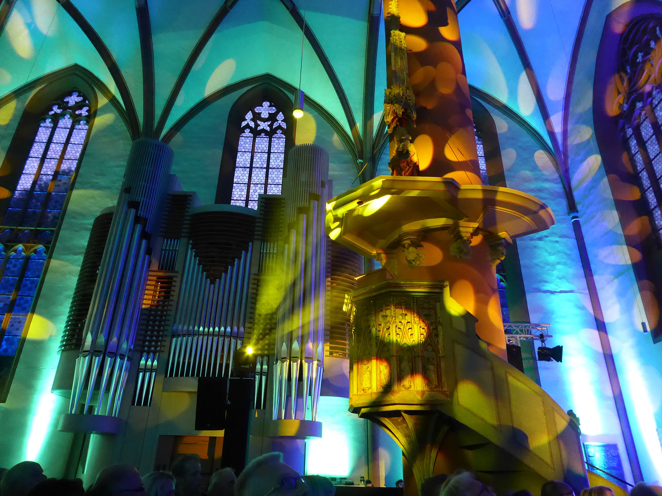 Grün, blau und gelb beleuchtete Orgel in einer gotischen Hallenkirche
