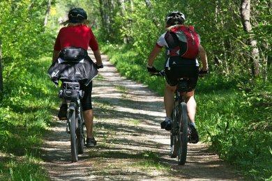 Radfahrer Zwei Radfahrer von hinten auf einem unbefestigten Weg im Laubwald