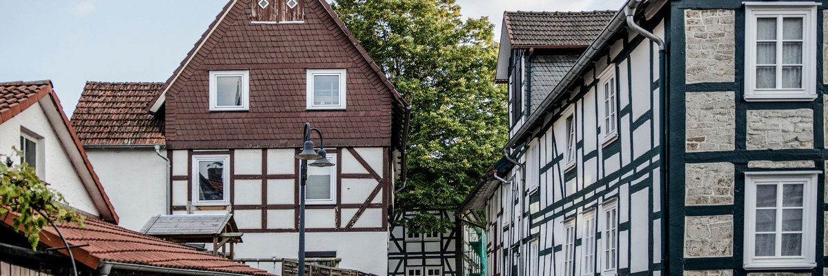 schmale Straße mit Fachwerkhäusern rechts und in der Bildmitte geradeaus